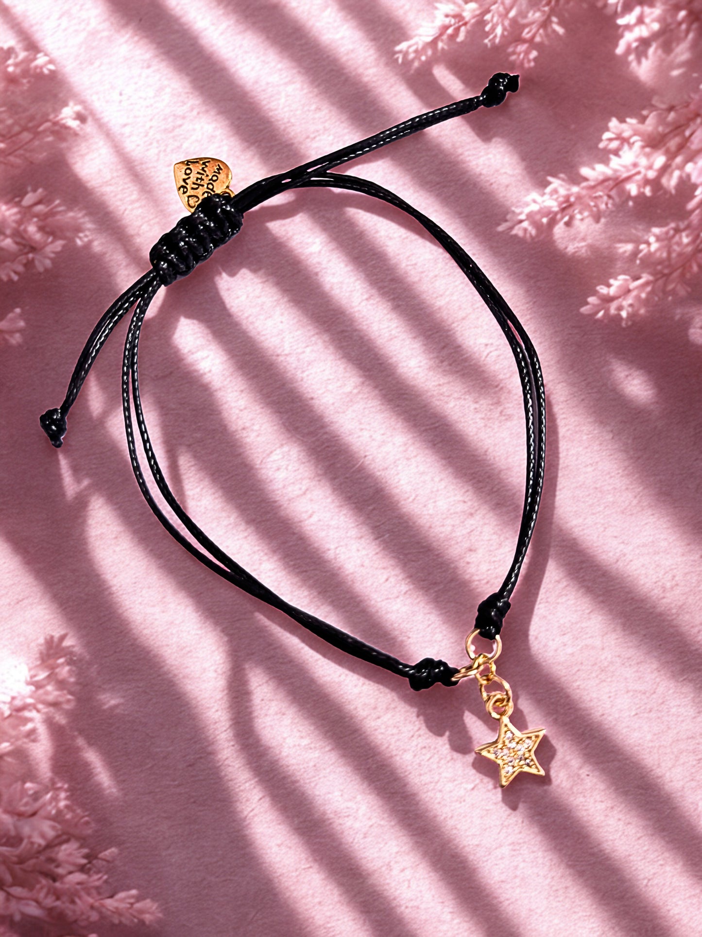 Golden Star charm bracelet on a pink background