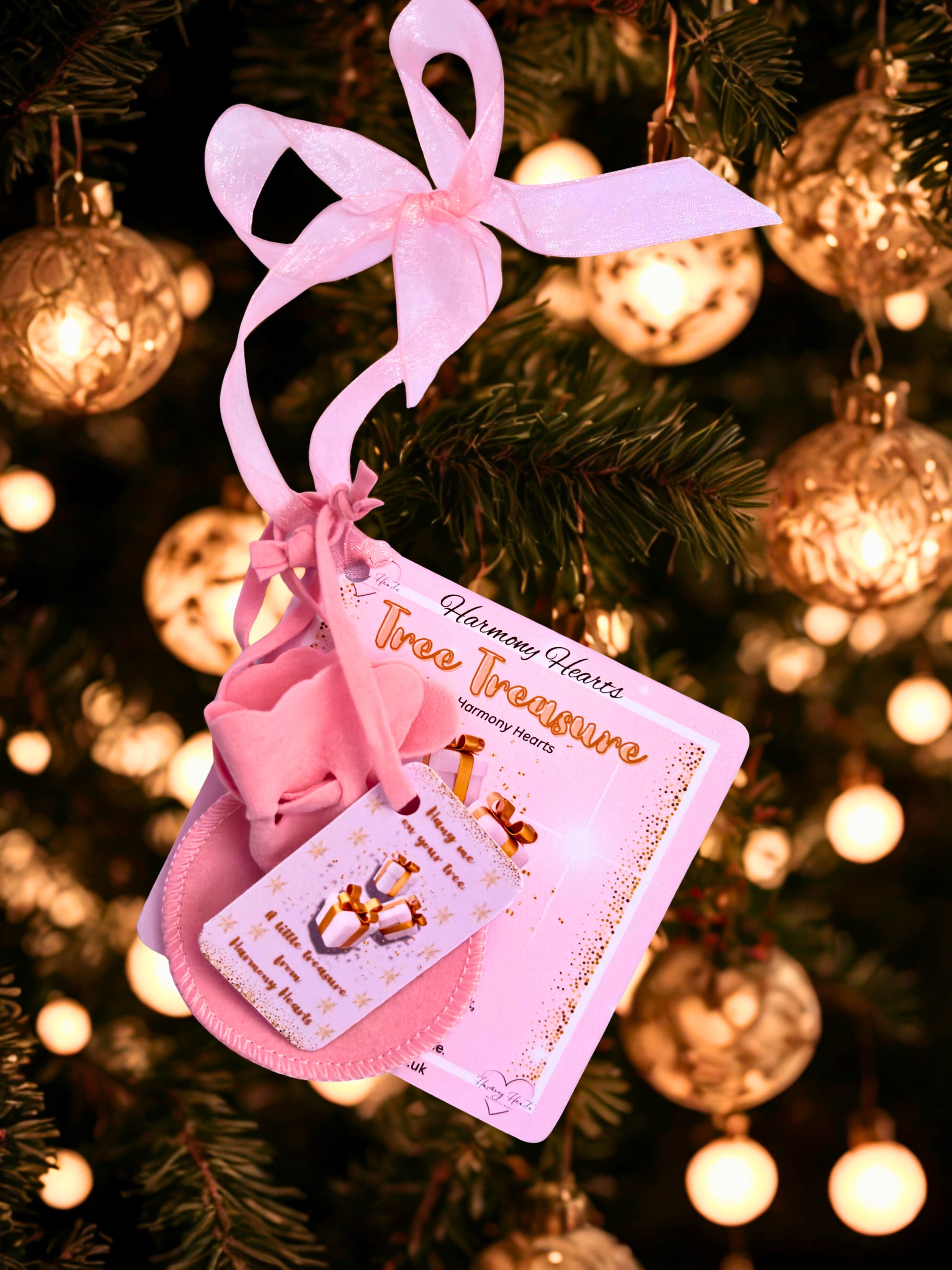 Pink decorative bow with a card on a Christmas tree
