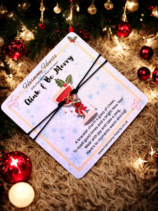 Christmas-themed card with a bracelet on a textured surface with festive decorations.