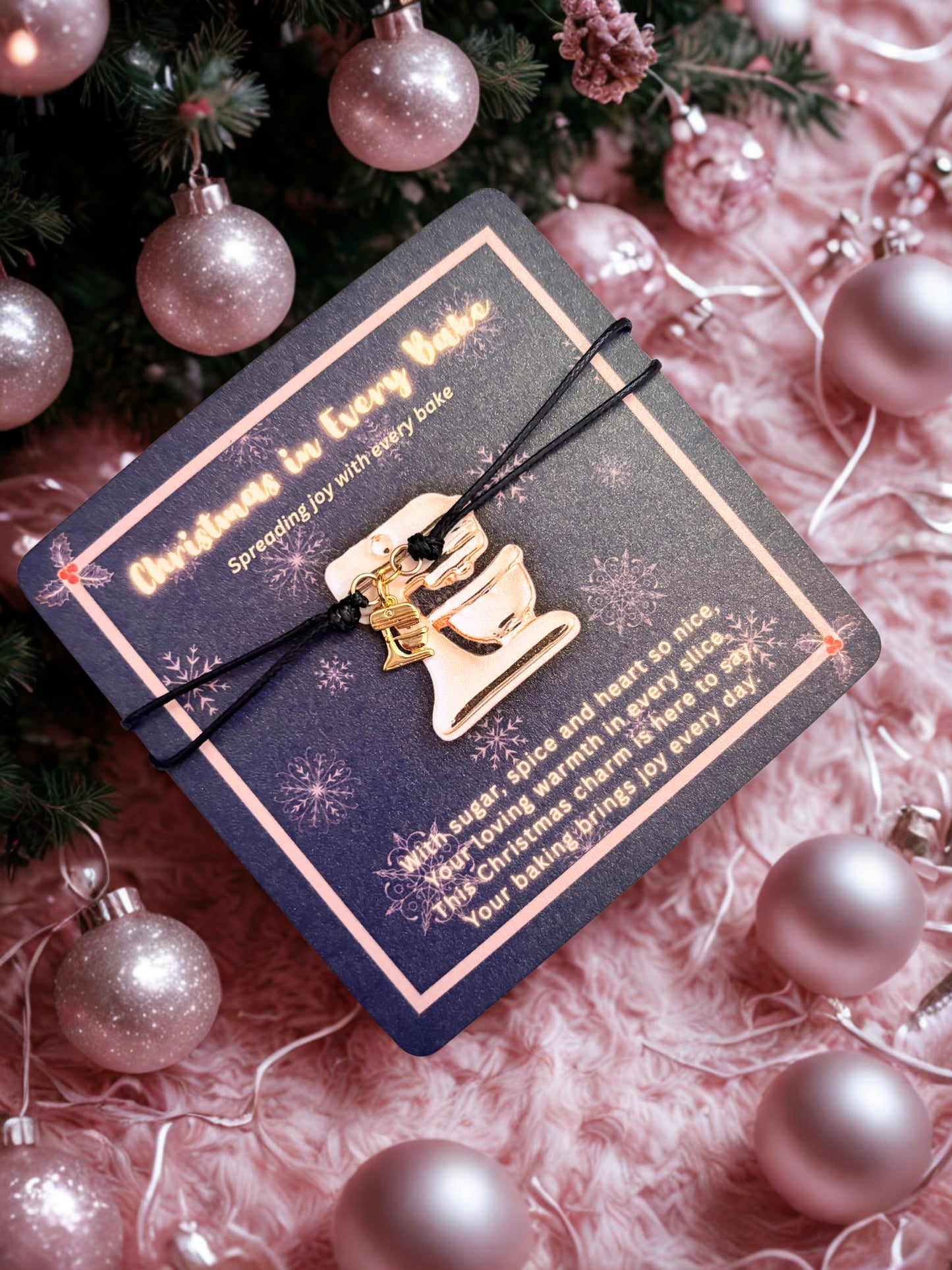 Decorative card with a gold food mixer charm on a pink textured background with Christmas ornaments.