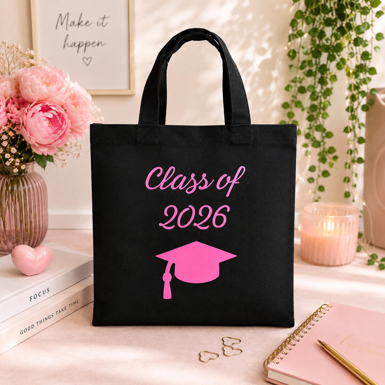 Black tote bag with 'Class of 2026' and graduation cap design on a decorative surface.