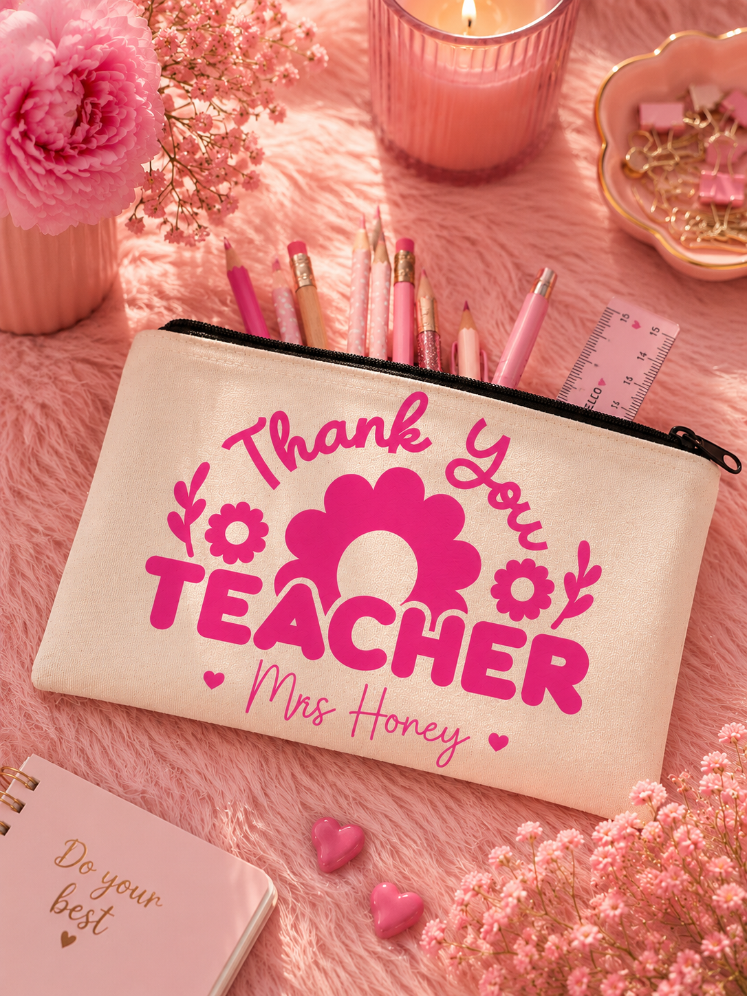 Beige pouch with 'Thank You Teacher' text on a pink surface with flowers and candles.