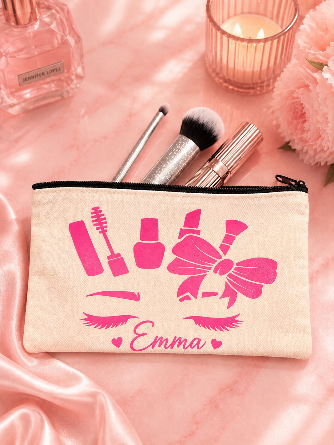 Makeup pouch with pink makeup icons and 'Emma' text on a pink surface with makeup items.