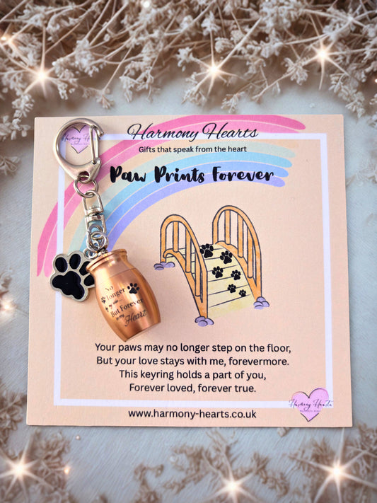 Keychain with paw print design on a card with 'Harmony Hearts' branding, surrounded by decorative elements.