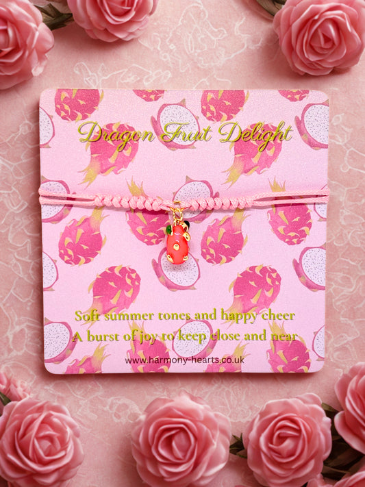 Pink cord bracelet with a dragon fruit charm presented on a branded Harmony Hearts card