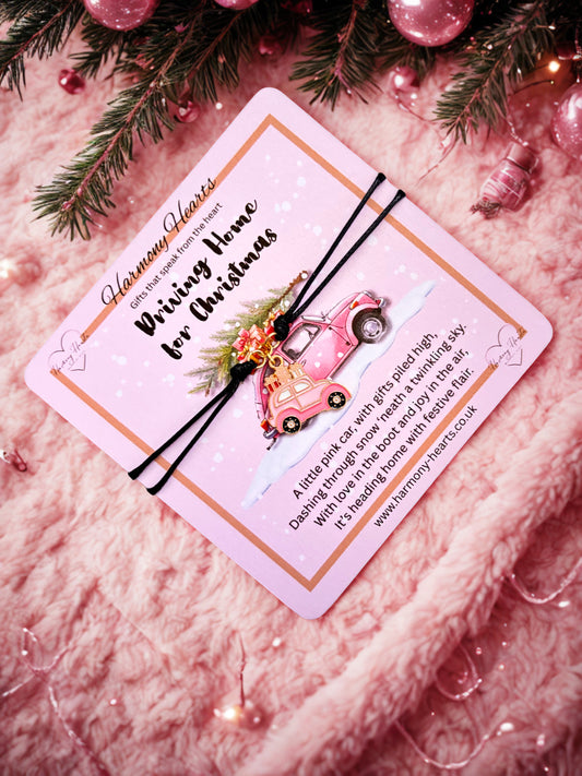 Pink card with a pink car illustration on and  a pink car charm bracelet with Christmas decorations.