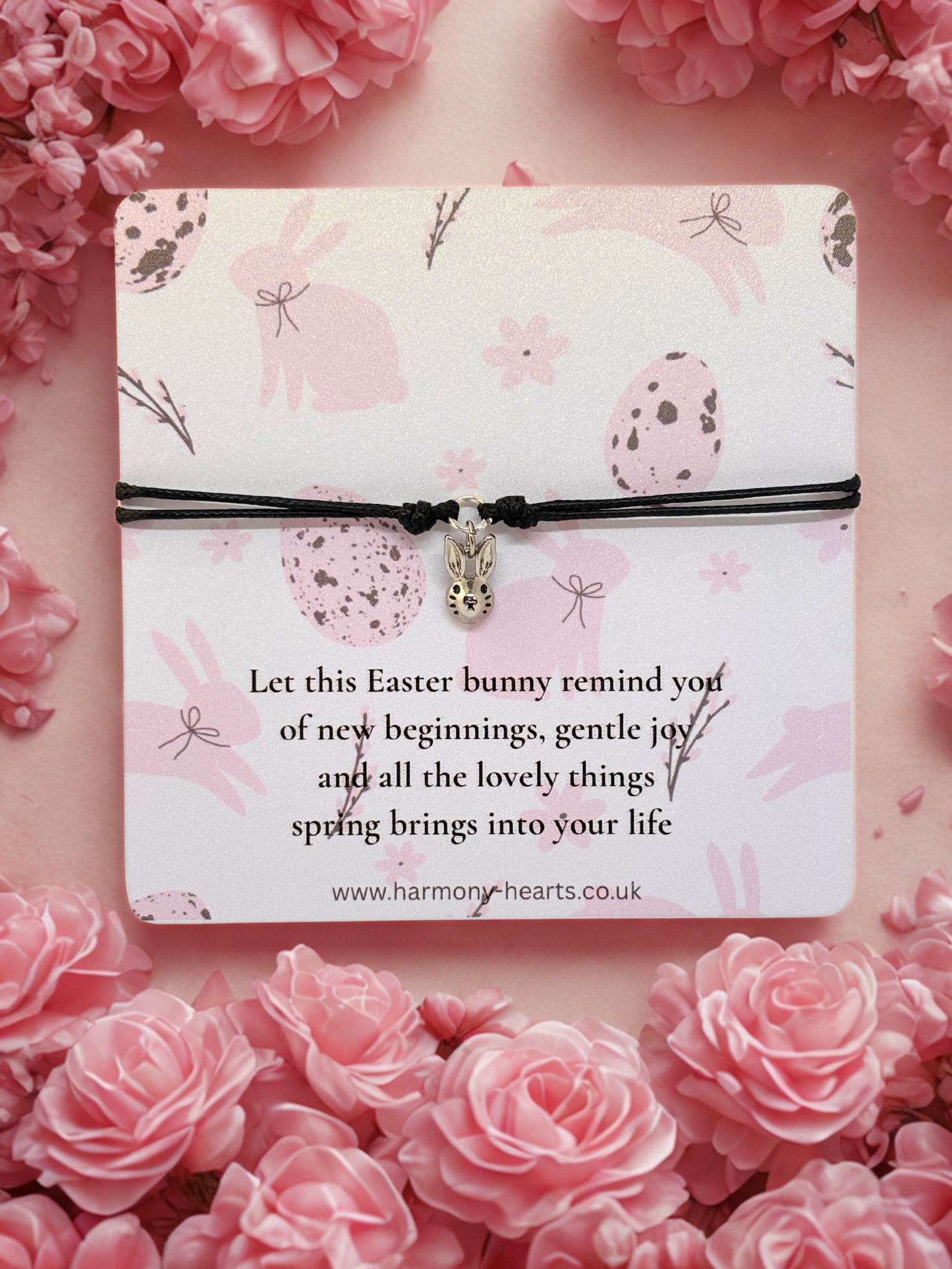 Bunny charm bracelet with an Easter message card on a pink floral background