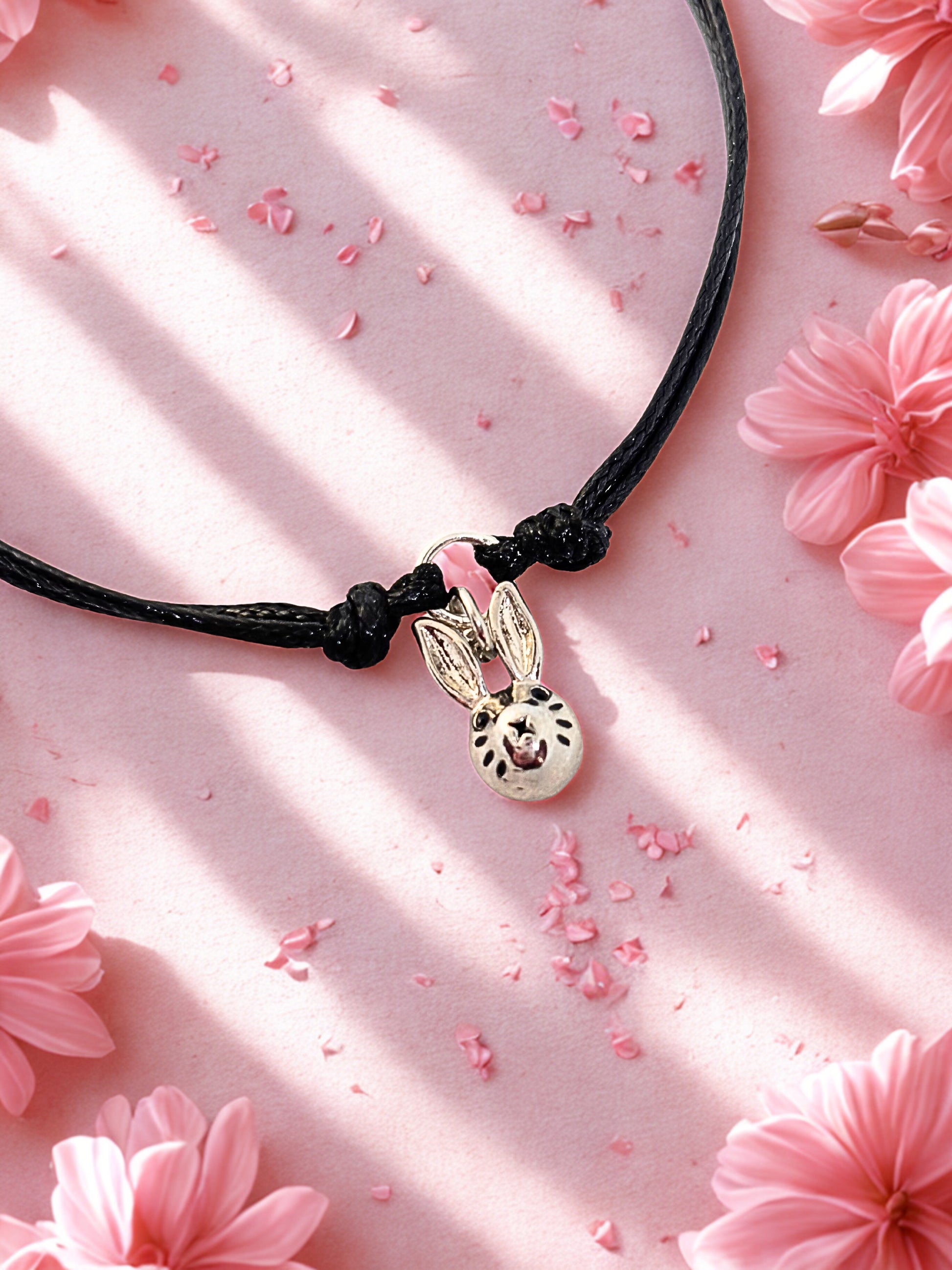 Charm bracelet with a bunny charm on a pink floral background