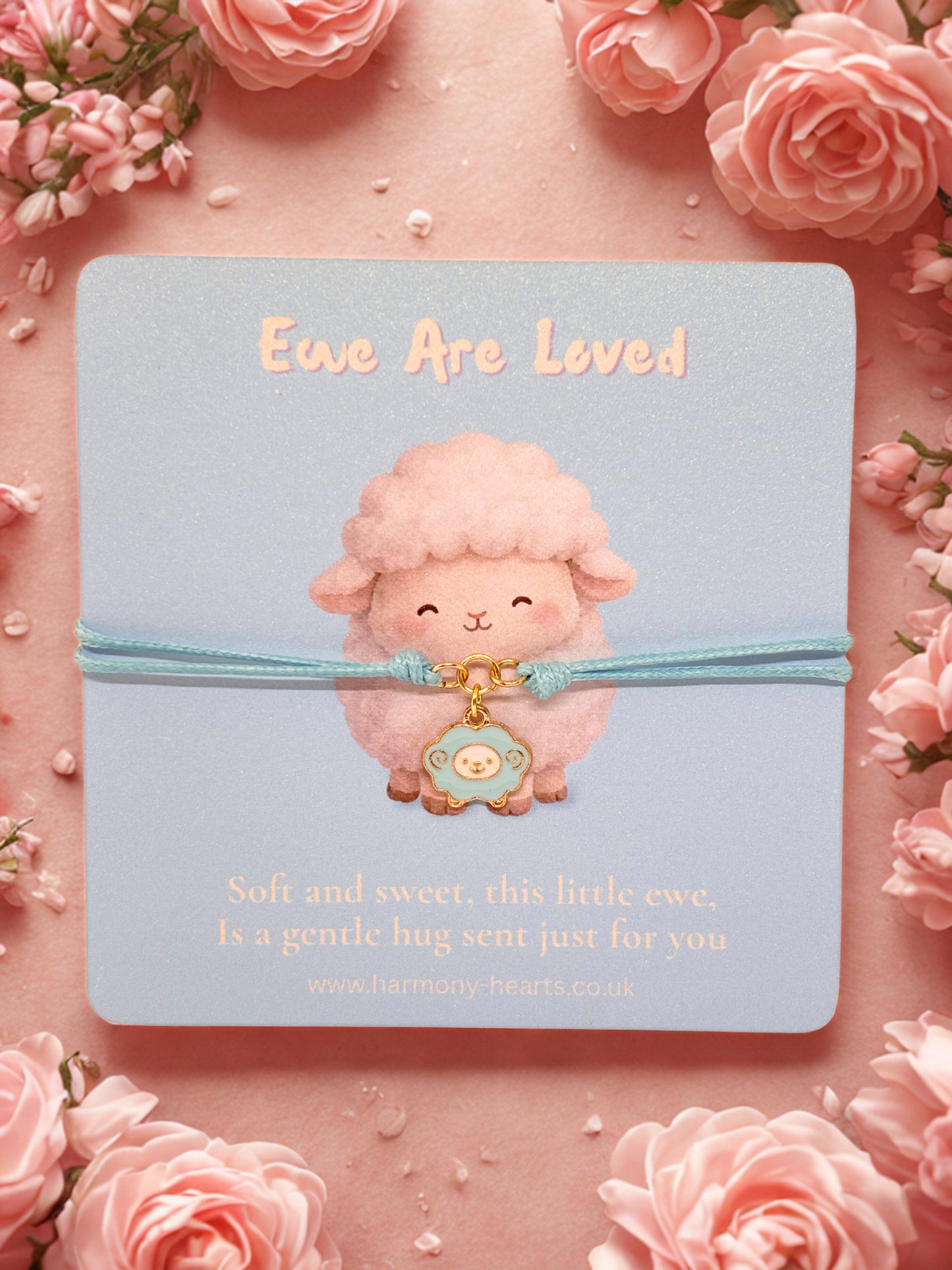 Blue cord bracelet with a sheep charm on a branded Harmony Hearts card with a cute sheep on a pink floral background