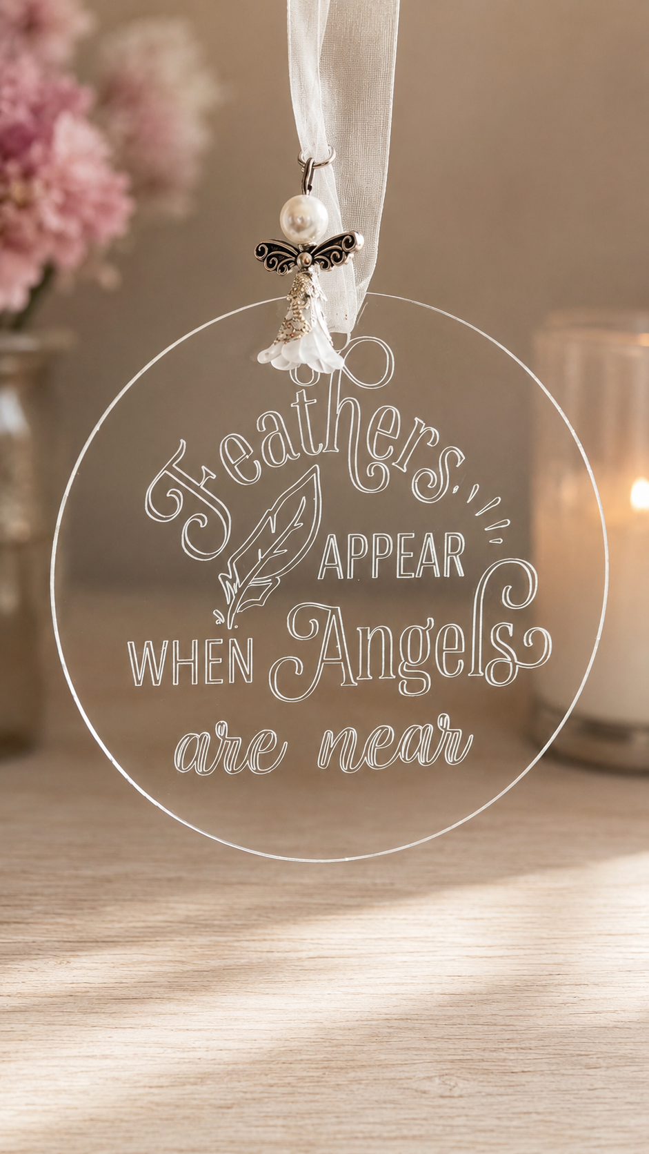 Round acrylic plaque engraved with the words Feathers appear when angels are near