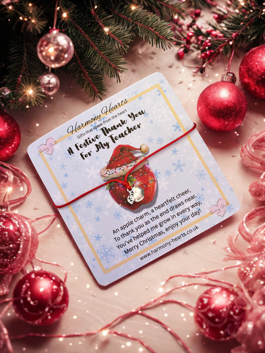 Card with apple charm and festive decorations on a wooden surface