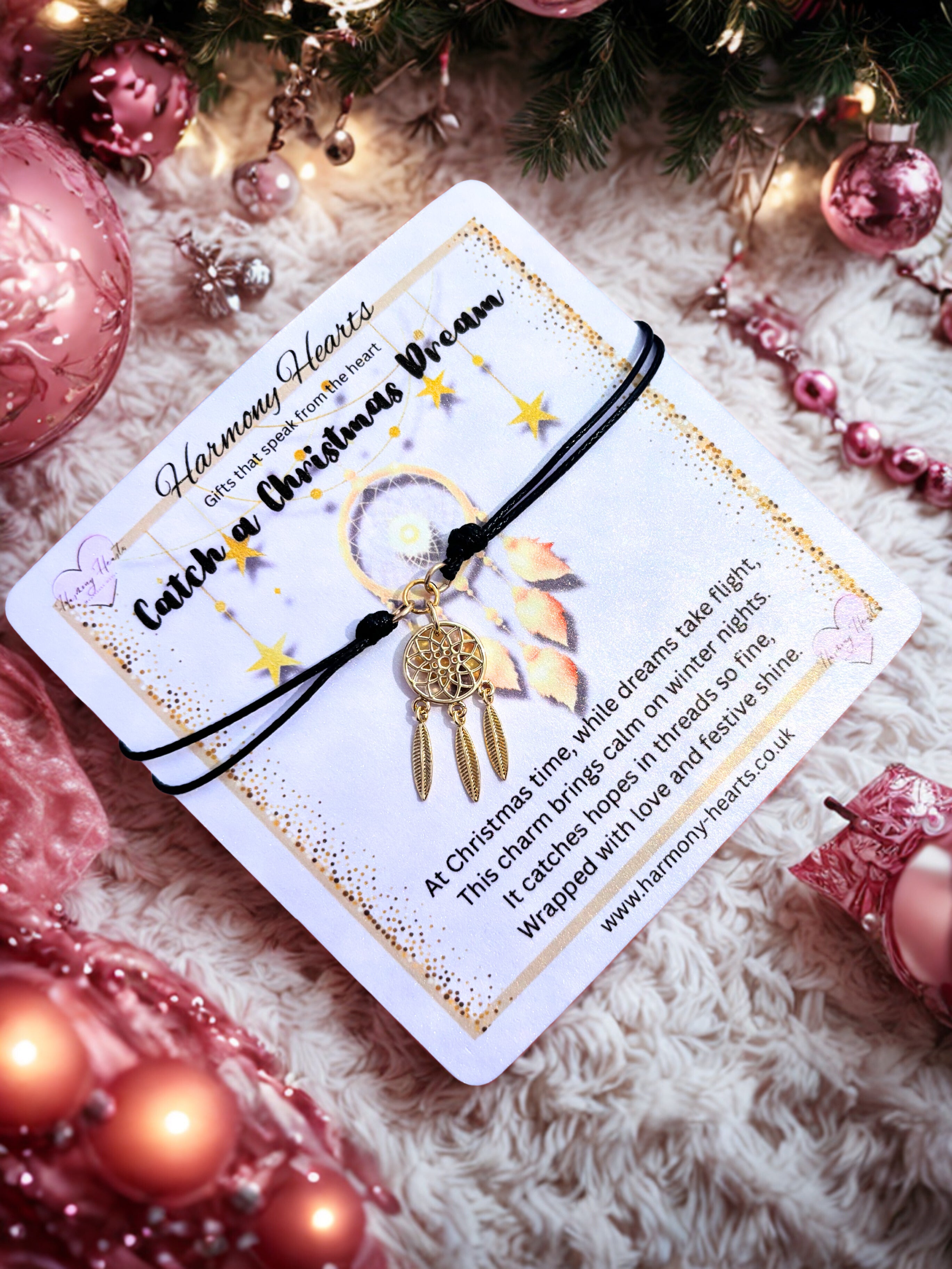 Decorative card with a dreamcatcher charm bracelet on a festive background with pink ornaments.