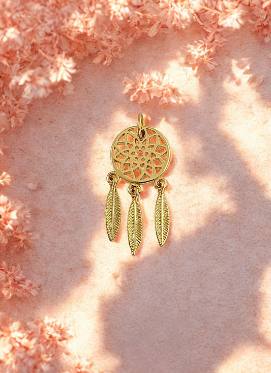 Gold dreamcatcher charm on a pink floral background