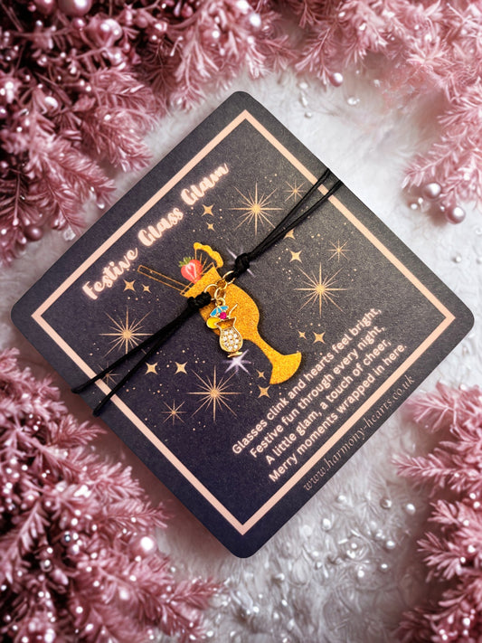 Decorative card with a gold cocktail charm bracelet on a pink textured background