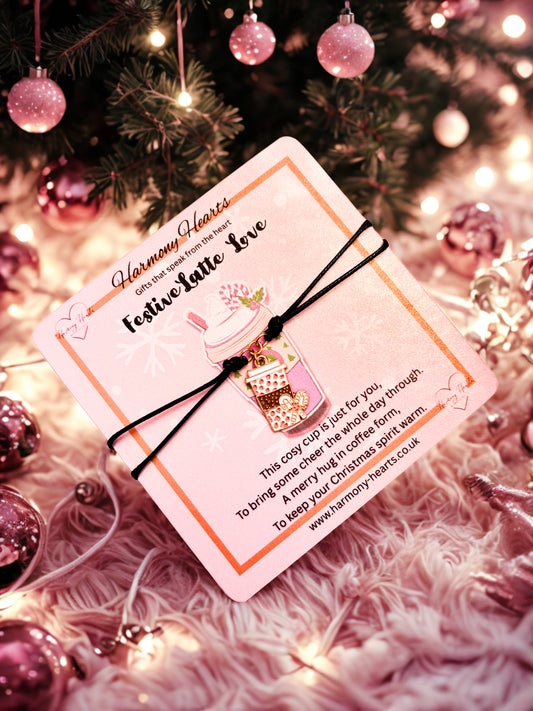 Coffee cup bracelet on a poem card on a Christmas-themed background with ornaments and lights.
