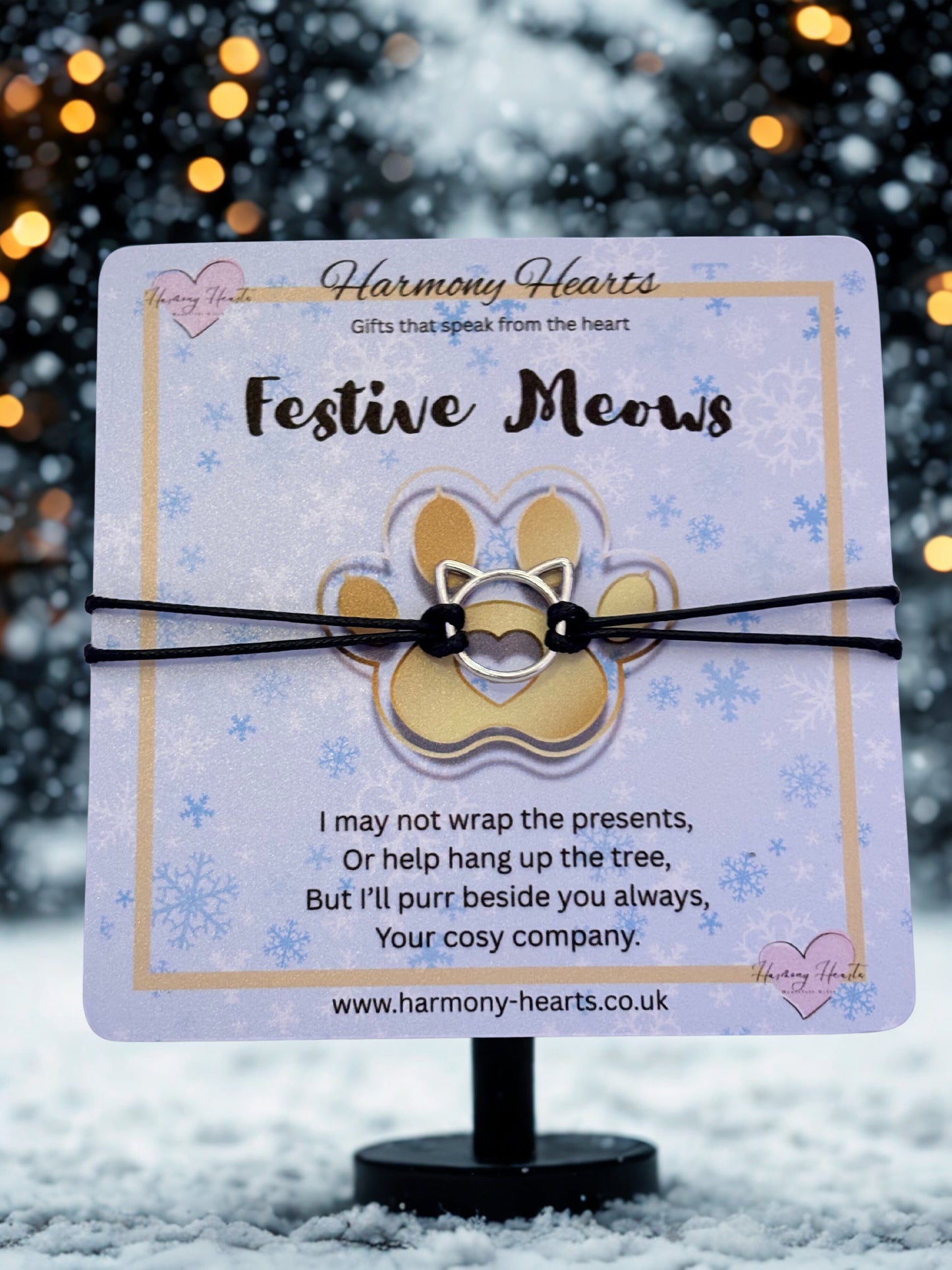 Cat-shaped bracelet on a decorative card with a festive background