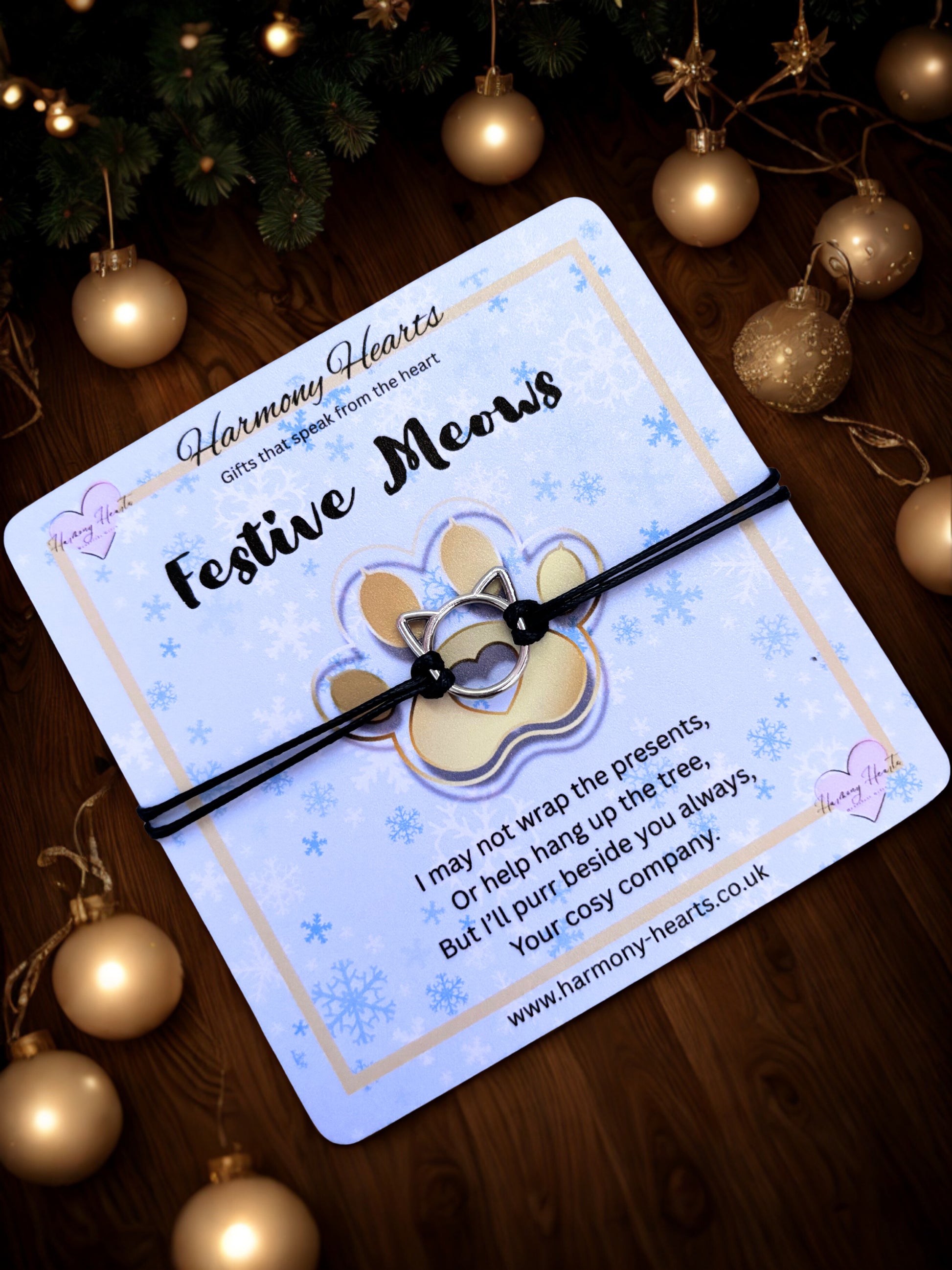 Festive Meows product packaging with a cat-themed design on a wooden surface with Christmas decorations.