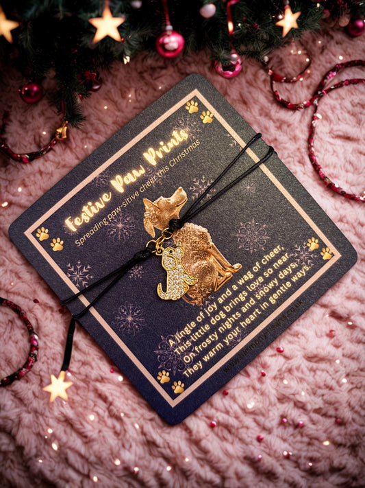 Gold dog charm on a decorative card with Christmas decorations in the background