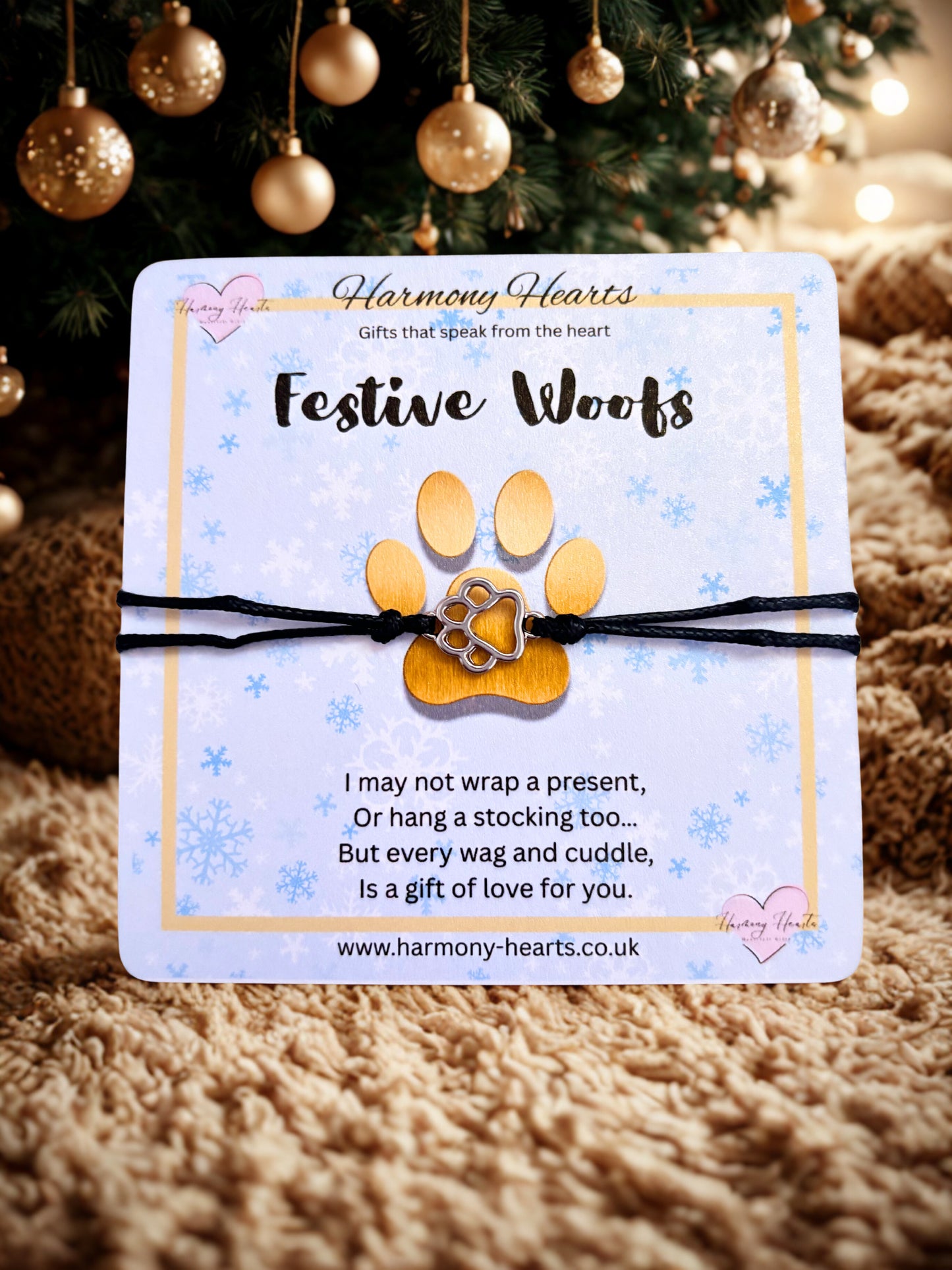 FestiveWoofs product with paw print design on a card in front of a Christmas tree.