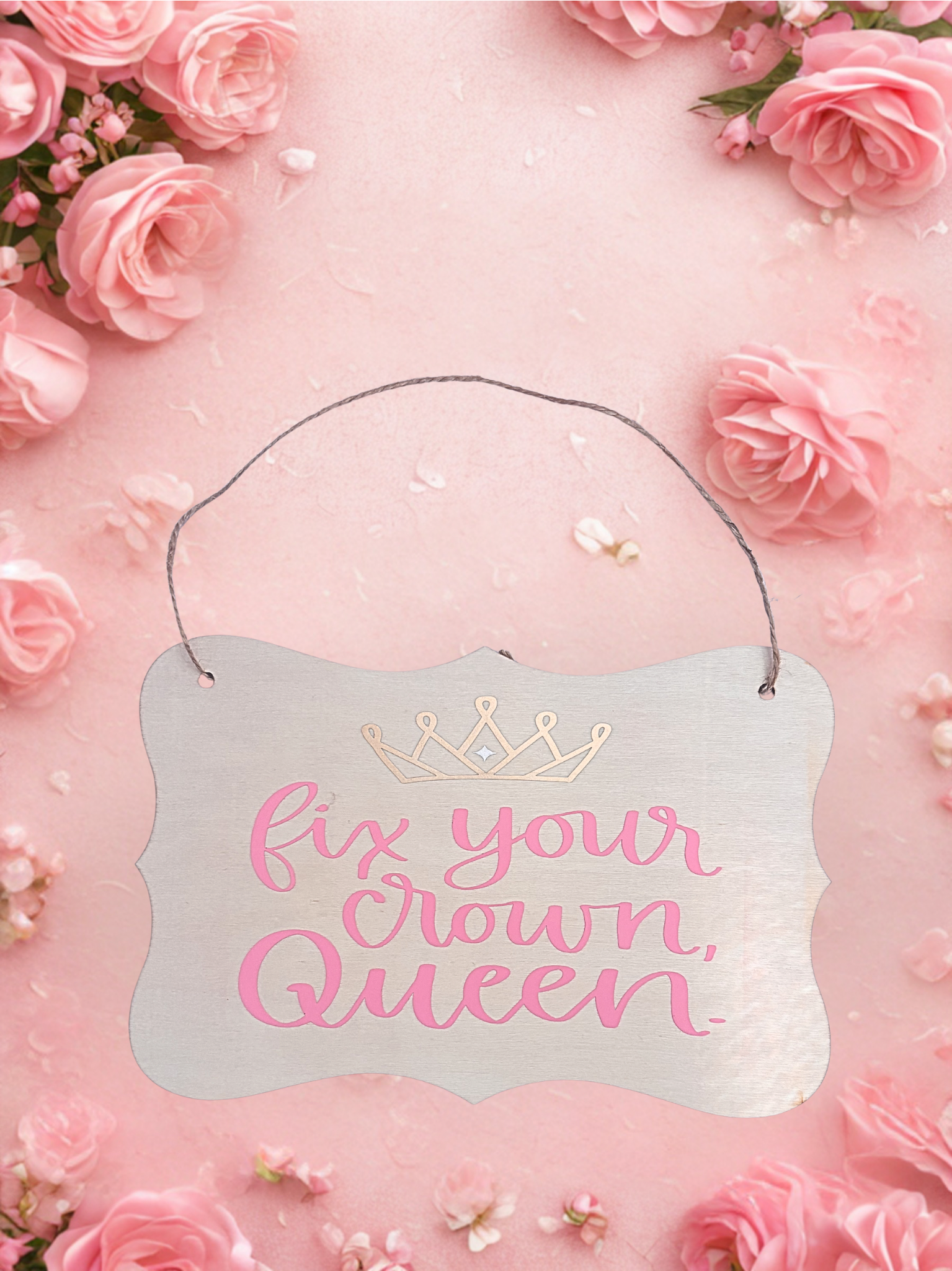 Decorative sign with 'fix your crown, Queen' text on a pink floral background