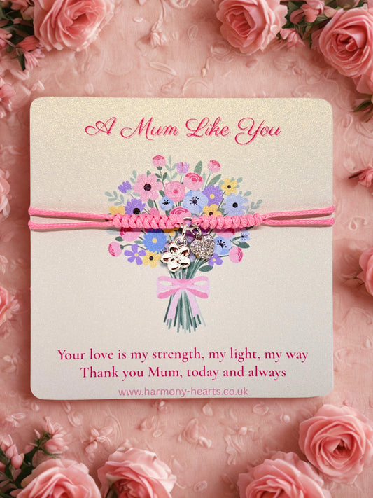 Pink cord bracelet with silver charms presented on a card with a floral design and text on a pink floral background