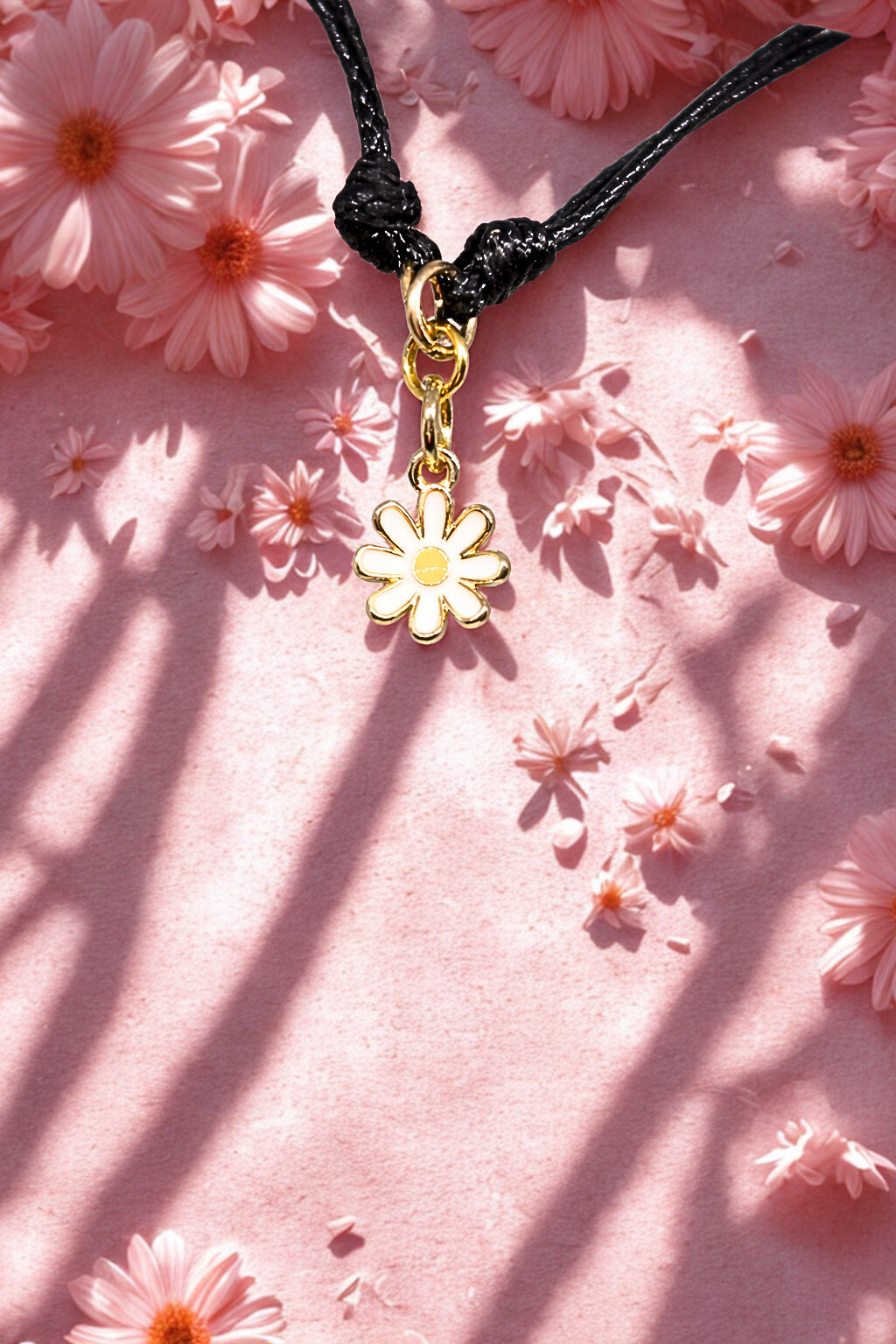Daisy charm bracelet on a soft pink floral background