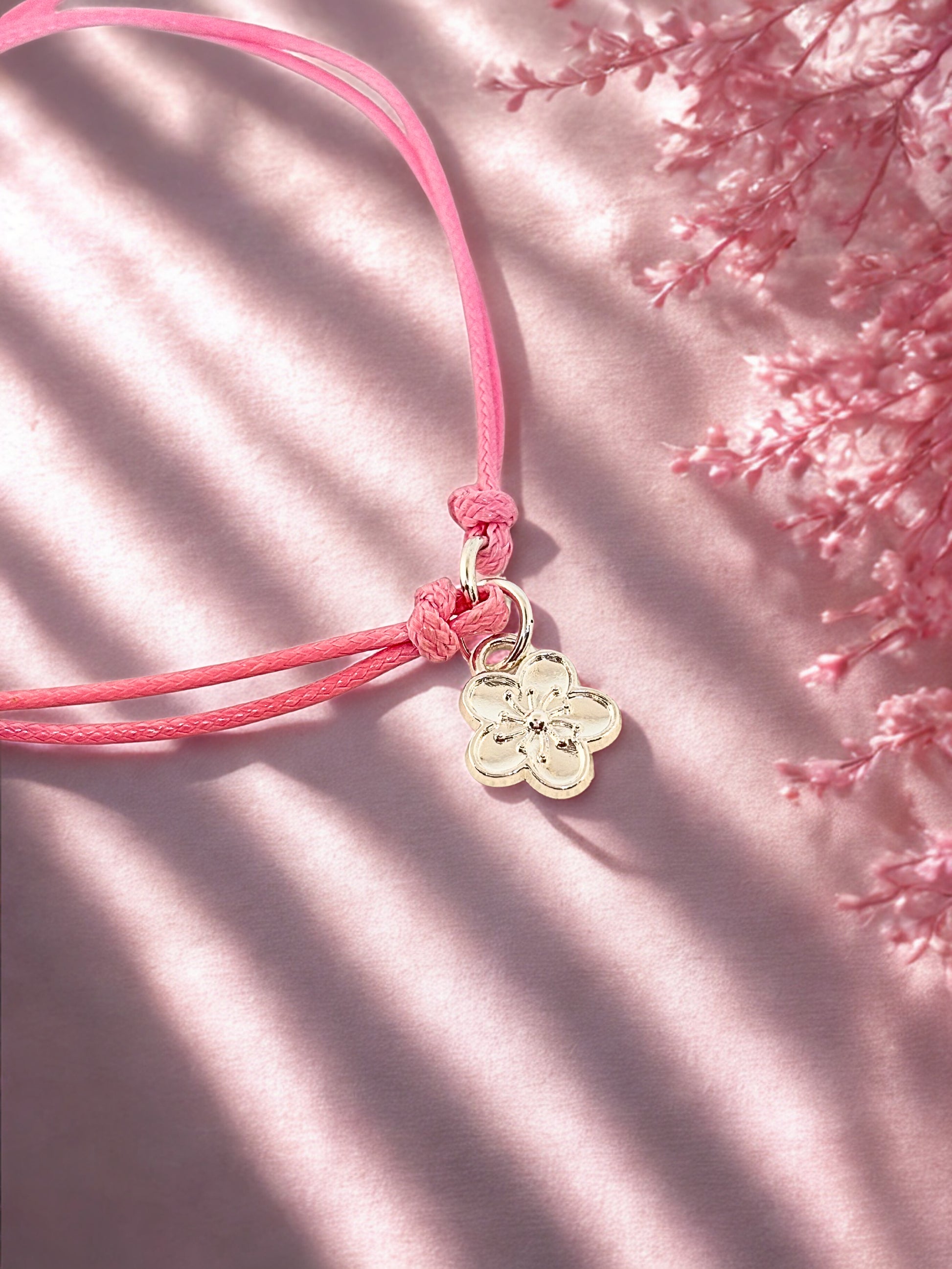 Pink cord charm bracelet with silver flower charm