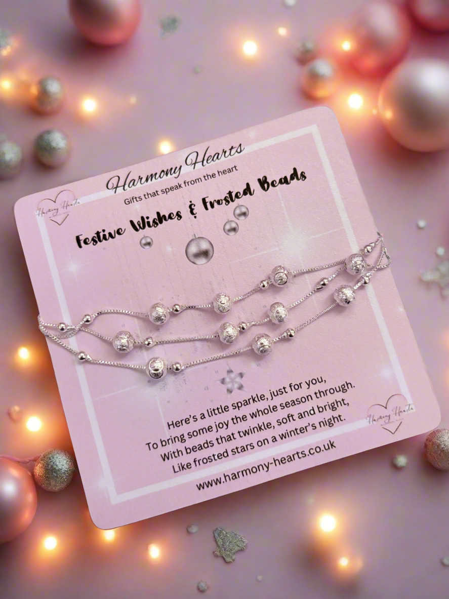 beaded bracelet on a pink card with 'Harmony Hearts' branding, surrounded by festive decorations.