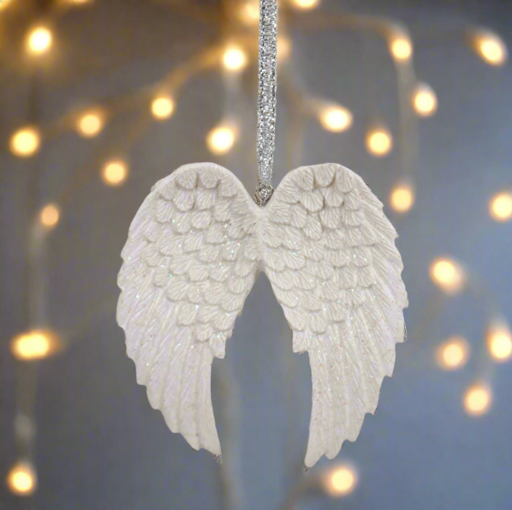 Decorative angel wings ornament against a blurred light background