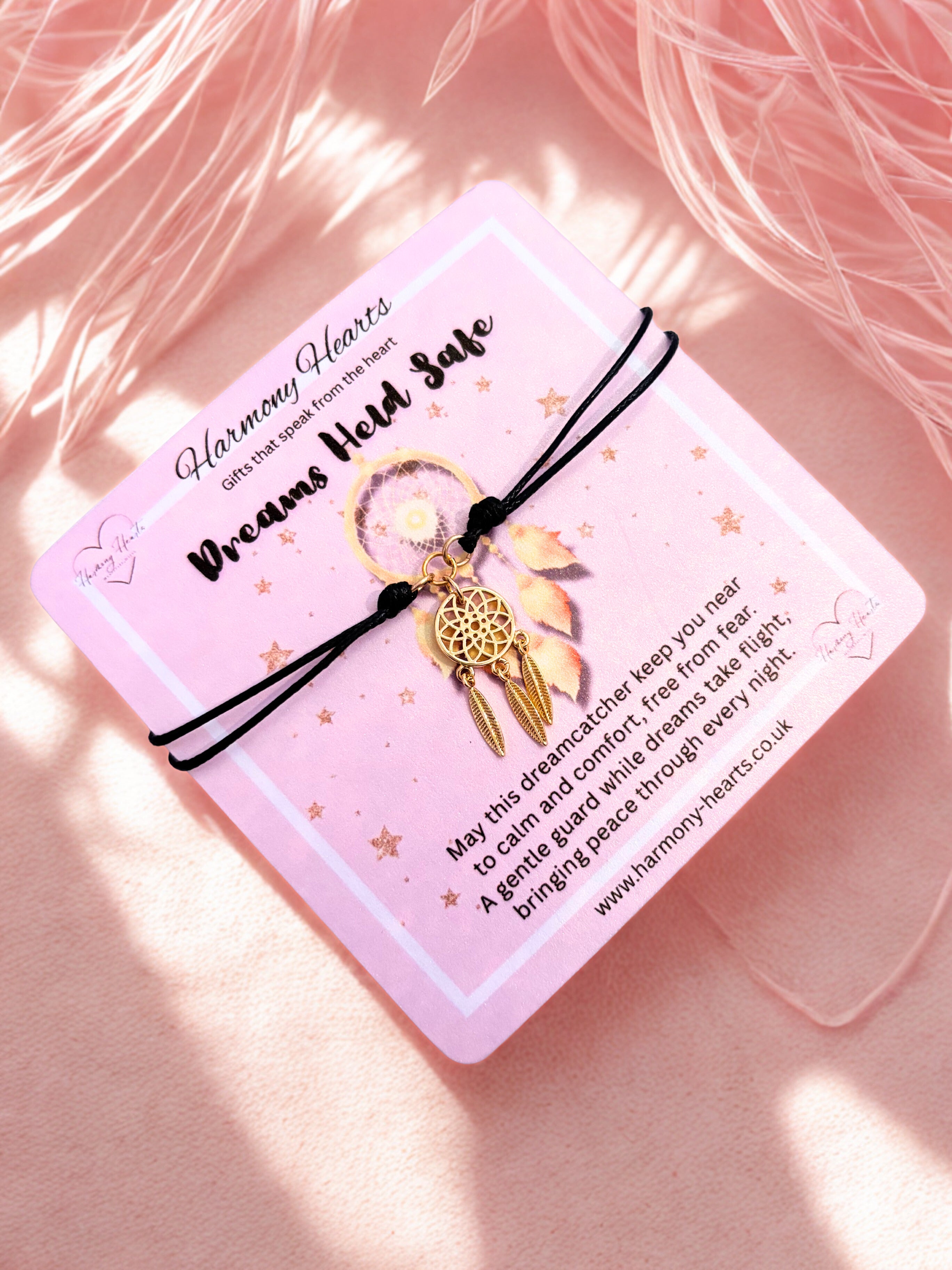 Dreamcatcher bracelet on a pink card with text on a soft pink background