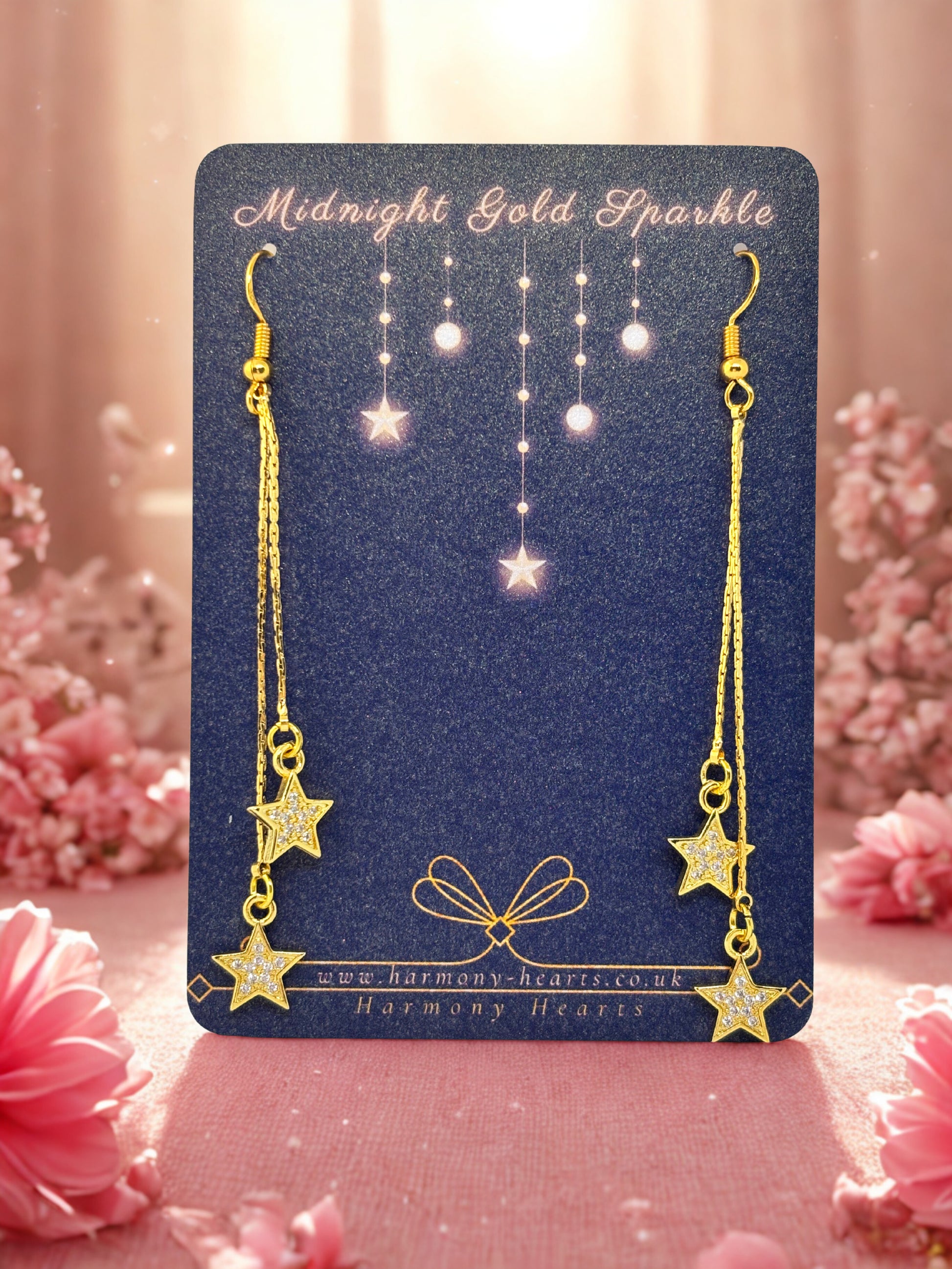 Gold star earrings on a 'Harmony Hearts' branded card with floral background