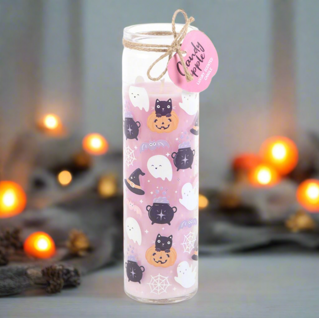 Decorative candle with Halloween-themed design and a pink label on a blurred background.