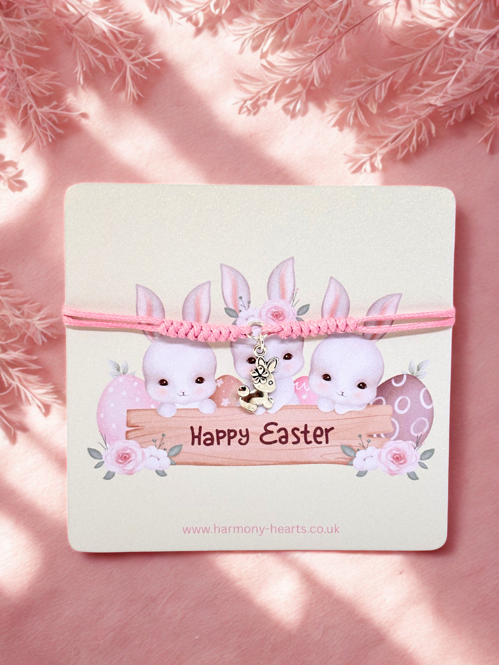 Pink bunny charm bracelet with 'Happy Easter' card on a pink background