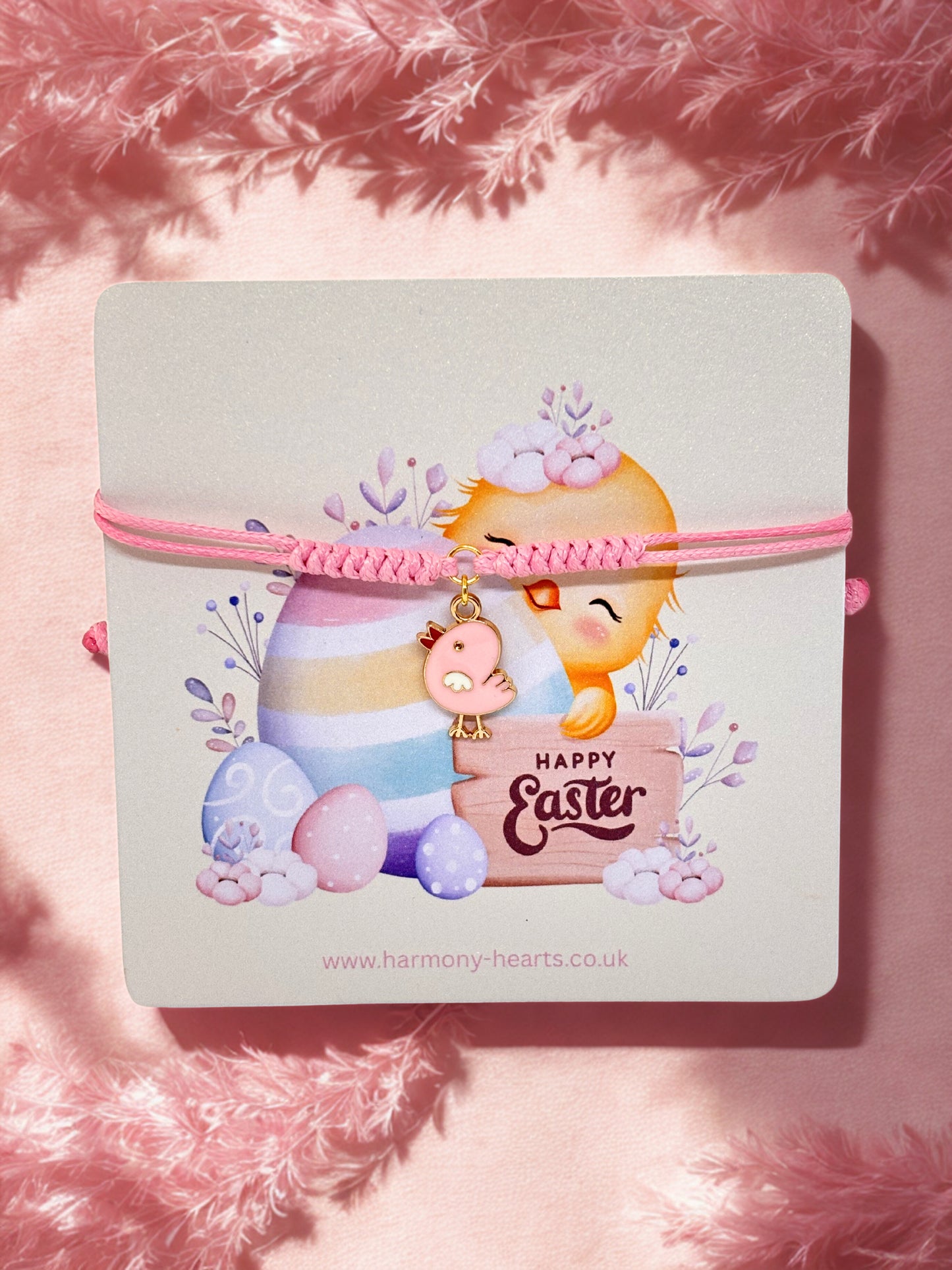 Pink cord bracelet with an Easter chick charm on an Easter illustrated card
