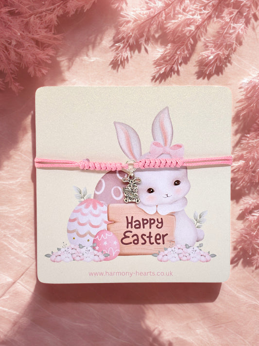 Pink cord bracelet with bunny charm on a branded Harmony Hearts card with a rabbit and Easter eggs design on a pink background