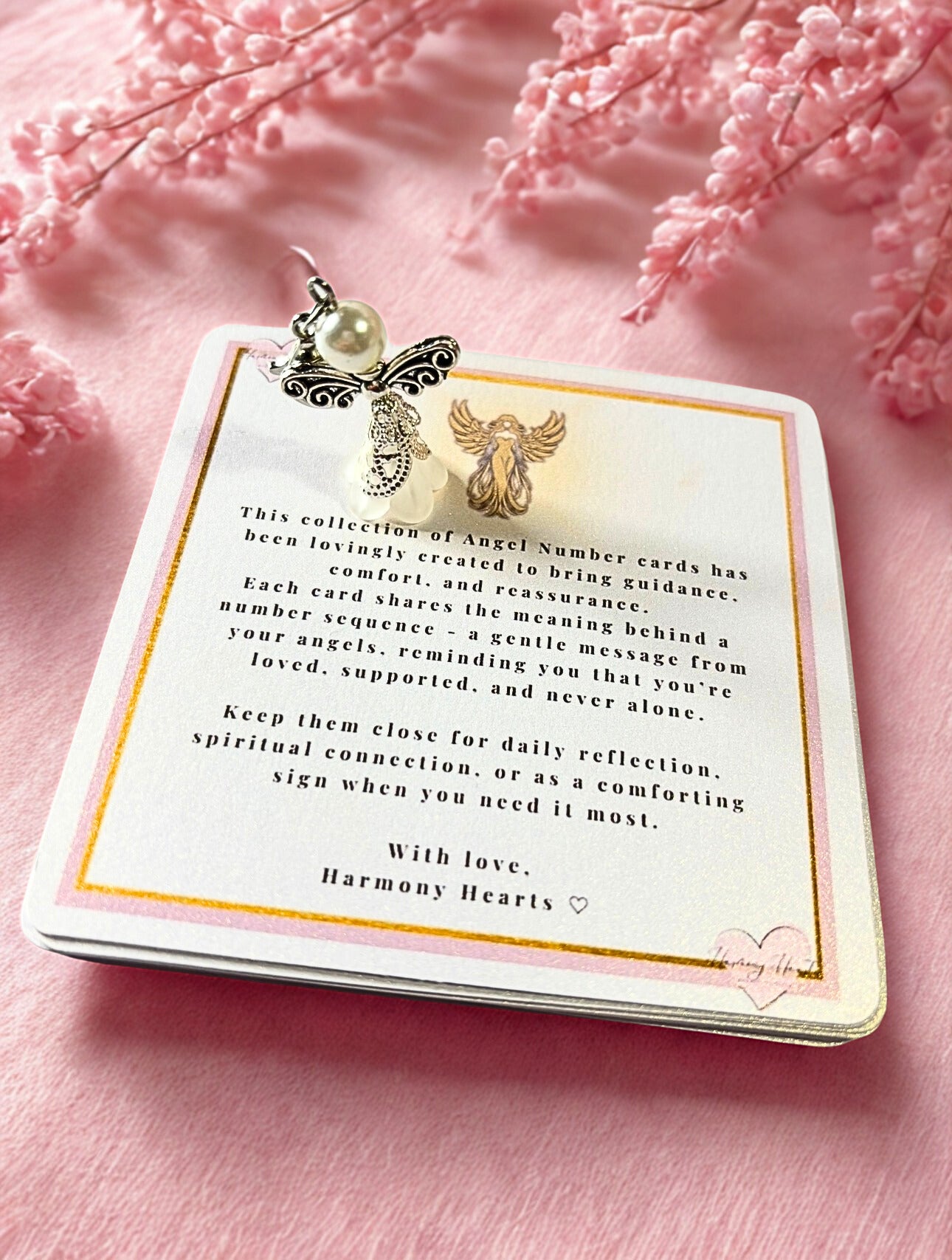 Card with angel number text and decorative elements on a pink background
