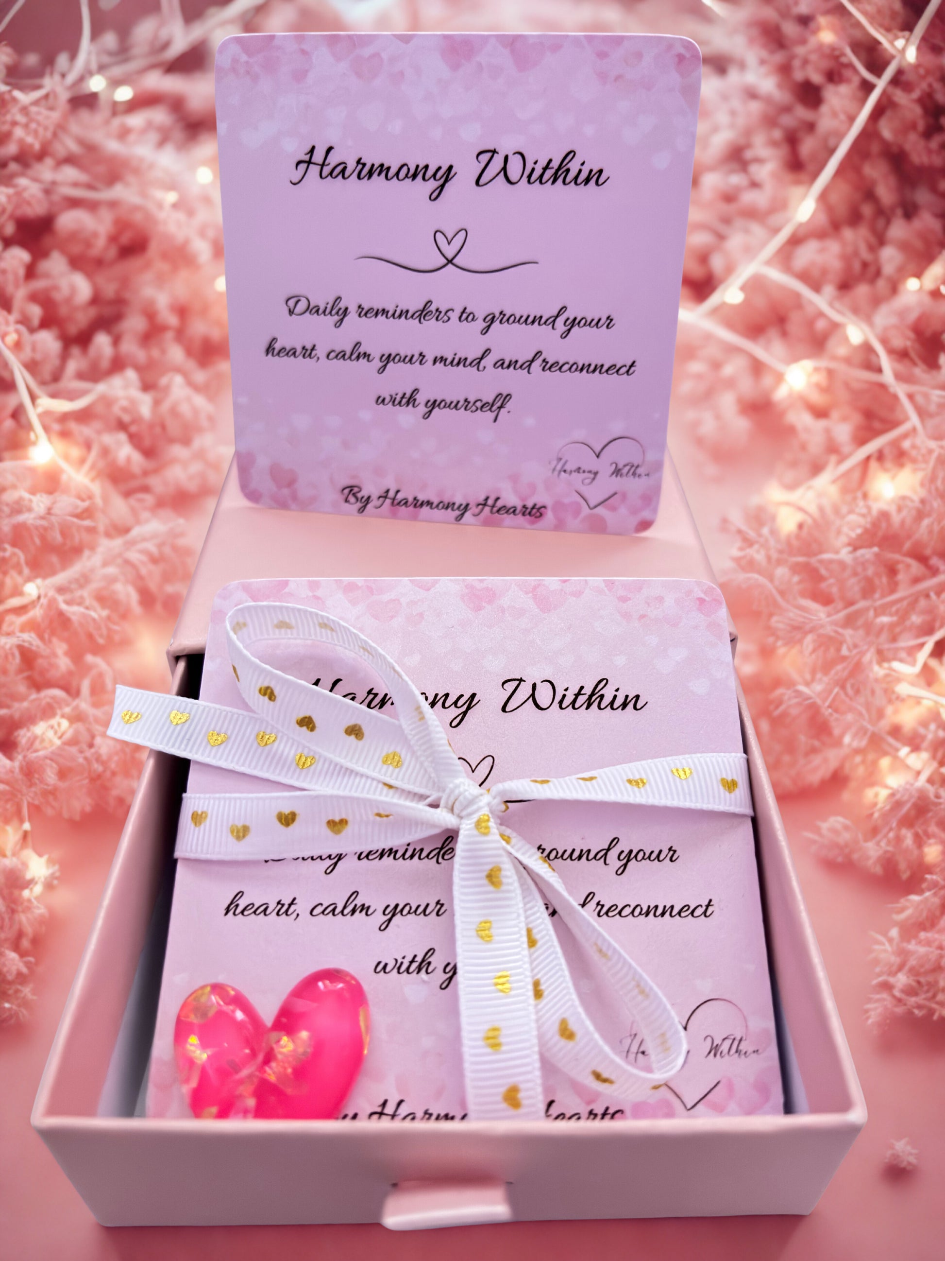 Pink gift box with 'Harmony Within' card and butterfly design on a soft pink background