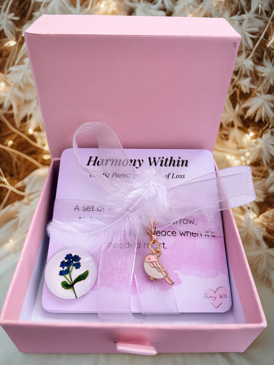 Pink jewelry box with 'Harmony Within' card and charms on a textured background