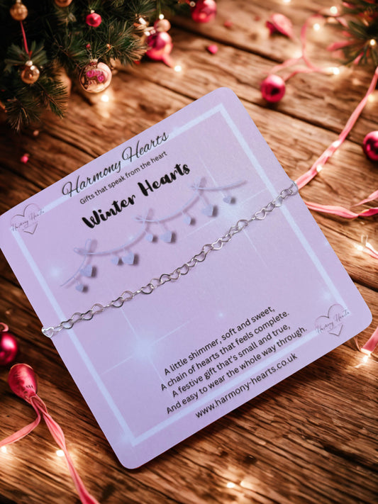 Silver bracelet on a 'Harmony Hearts' card with Christmas decorations in the background