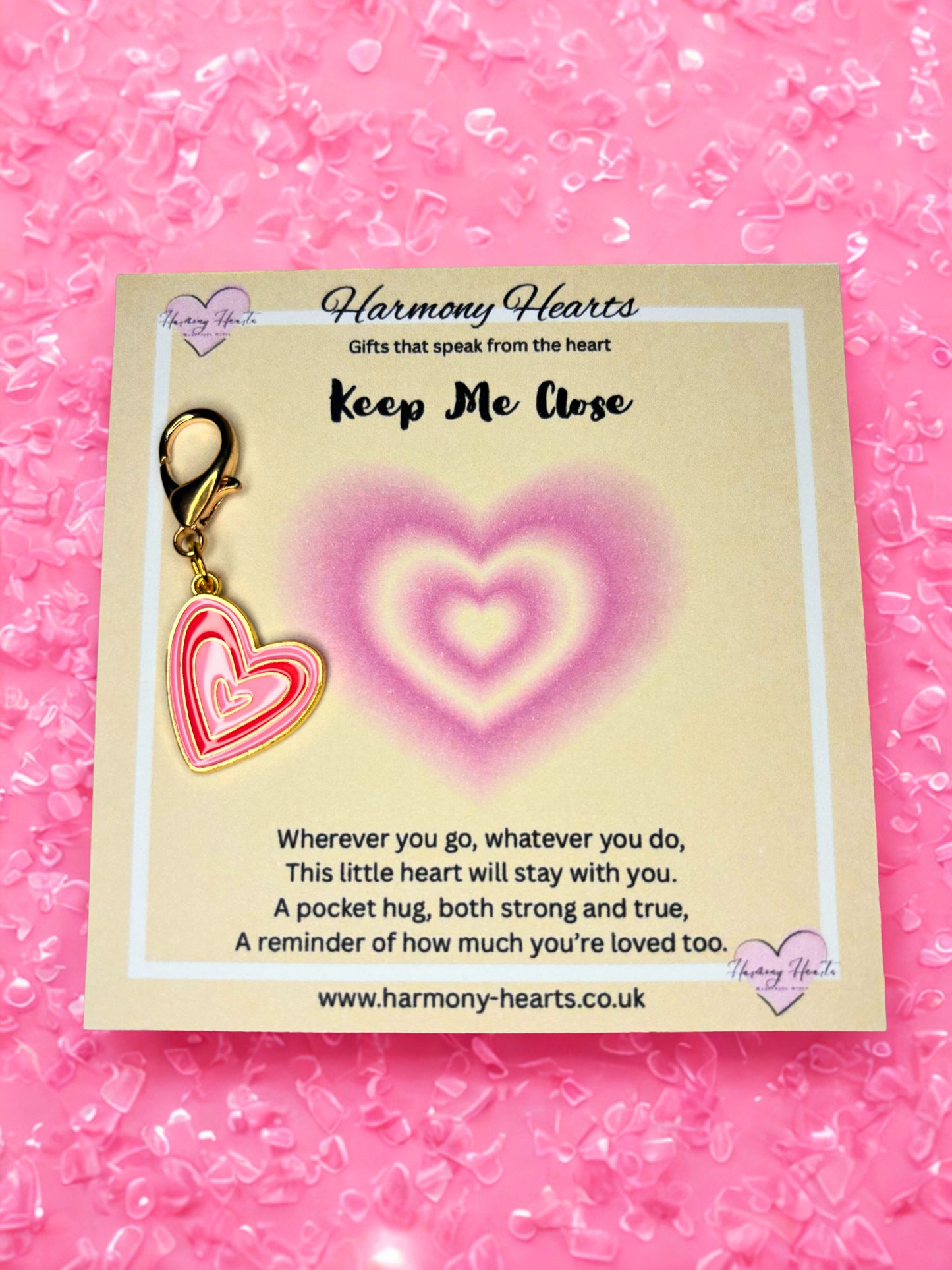 Heart-shaped keychain on a Harmony Hearts card with pink background