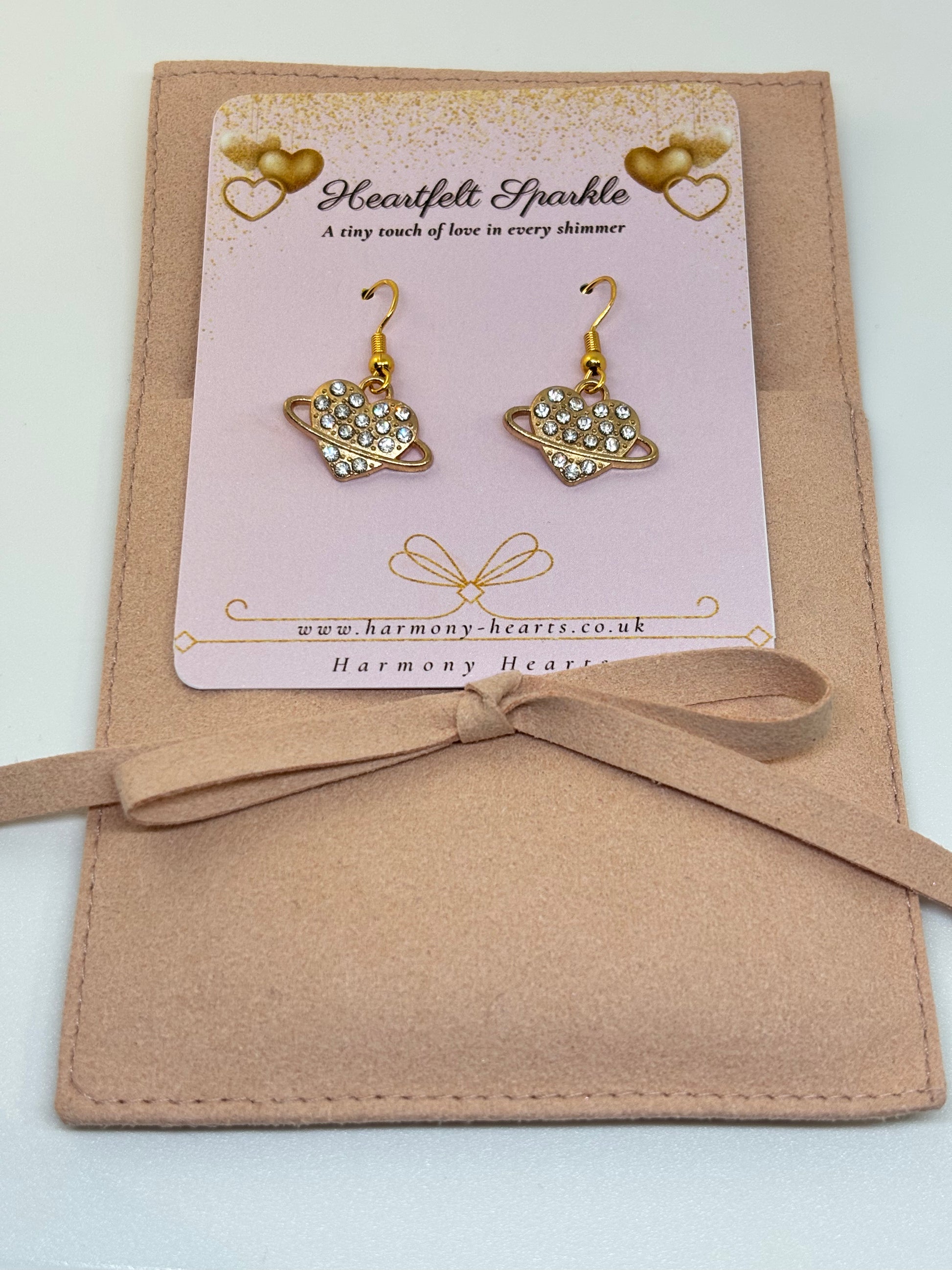 Heart-shaped earrings on a 'Heartfelt Sparkle' card with a bow on a beige background