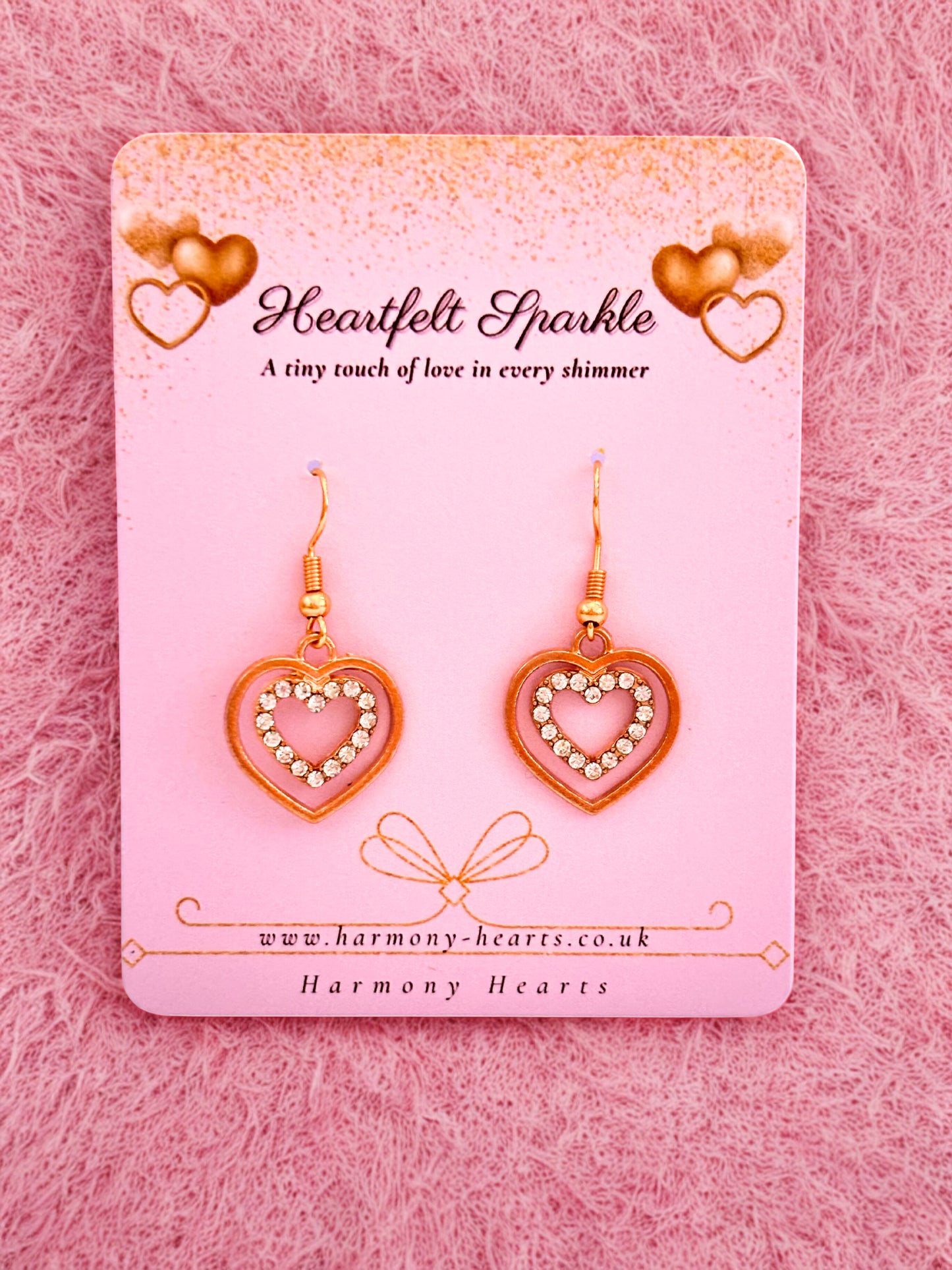 Heart-shaped earrings on a 'Heartfelt Sparkle' card with a pink background