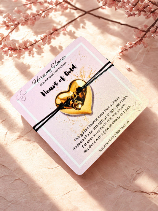 Gold heart-shaped bracelet on a card with cherry blossoms in the background