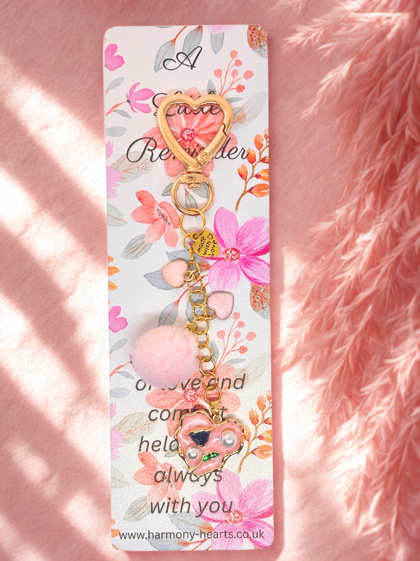 Decorative keychain bag charm with floral design on a pink fluffy background