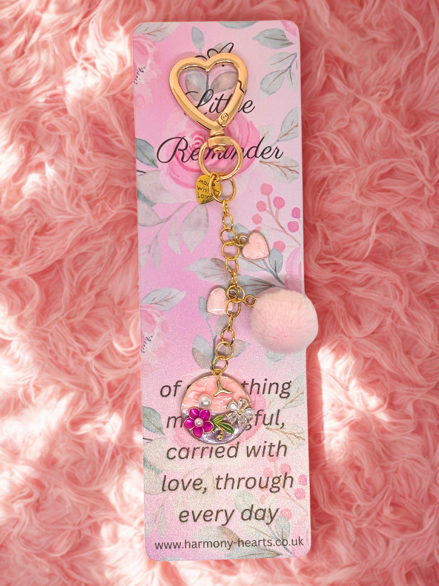 Decorative keychain bag charm with floral design on a pink fluffy background