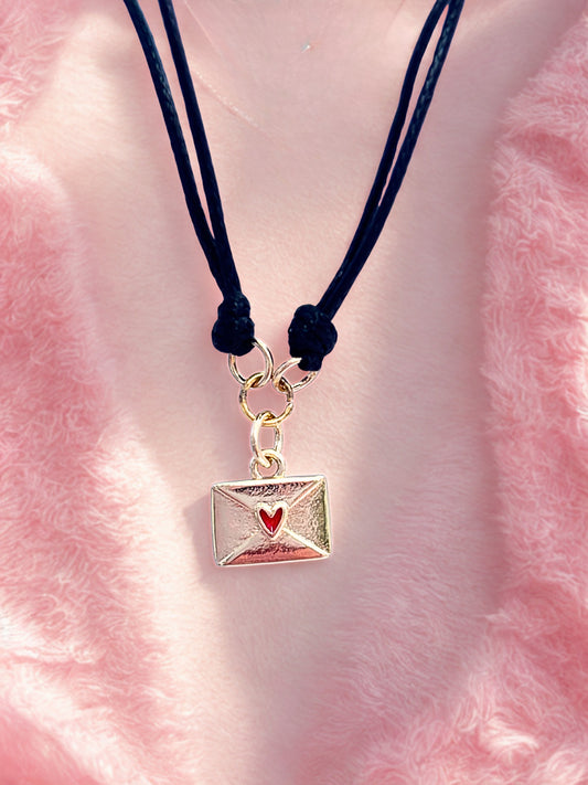 Bracelet with a gold envelope charm on a pink fluffy background