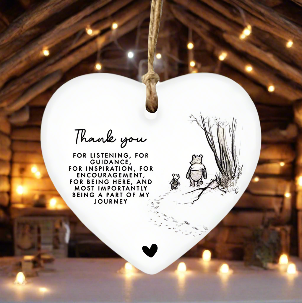 Heart-shaped hanging ornament with a message and illustrations on a white background
