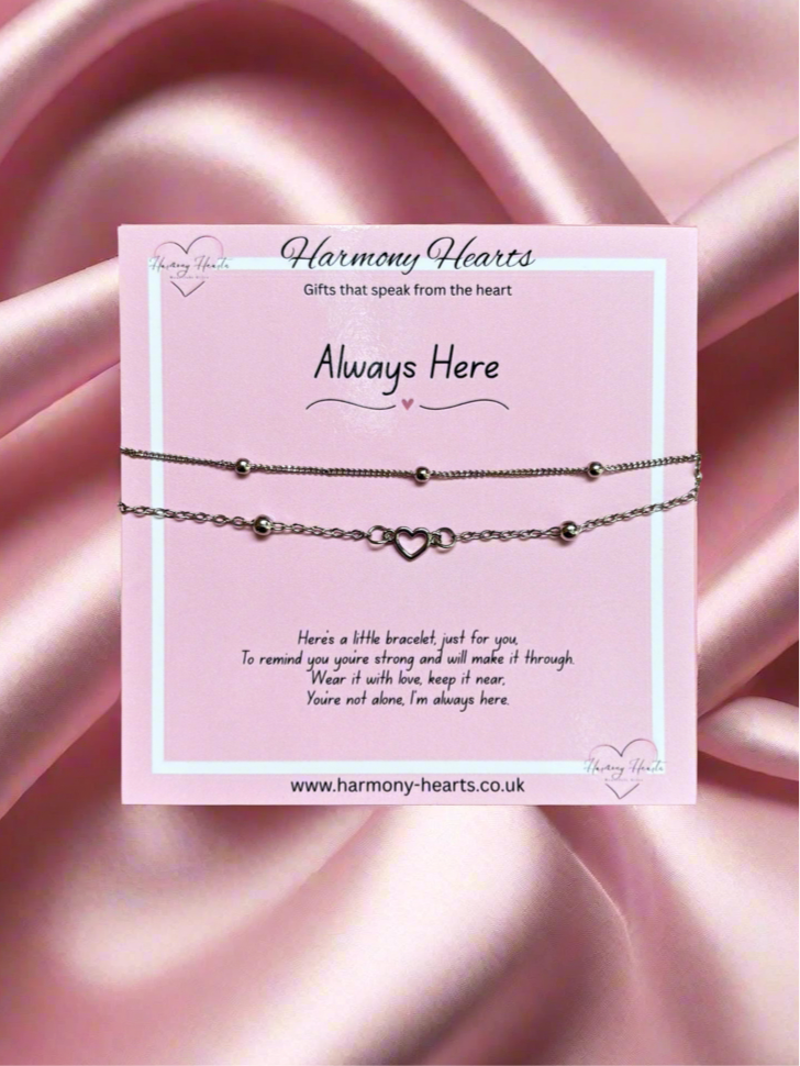 Bracelet on a card with 'Harmony Hearts' branding against a pink satin background