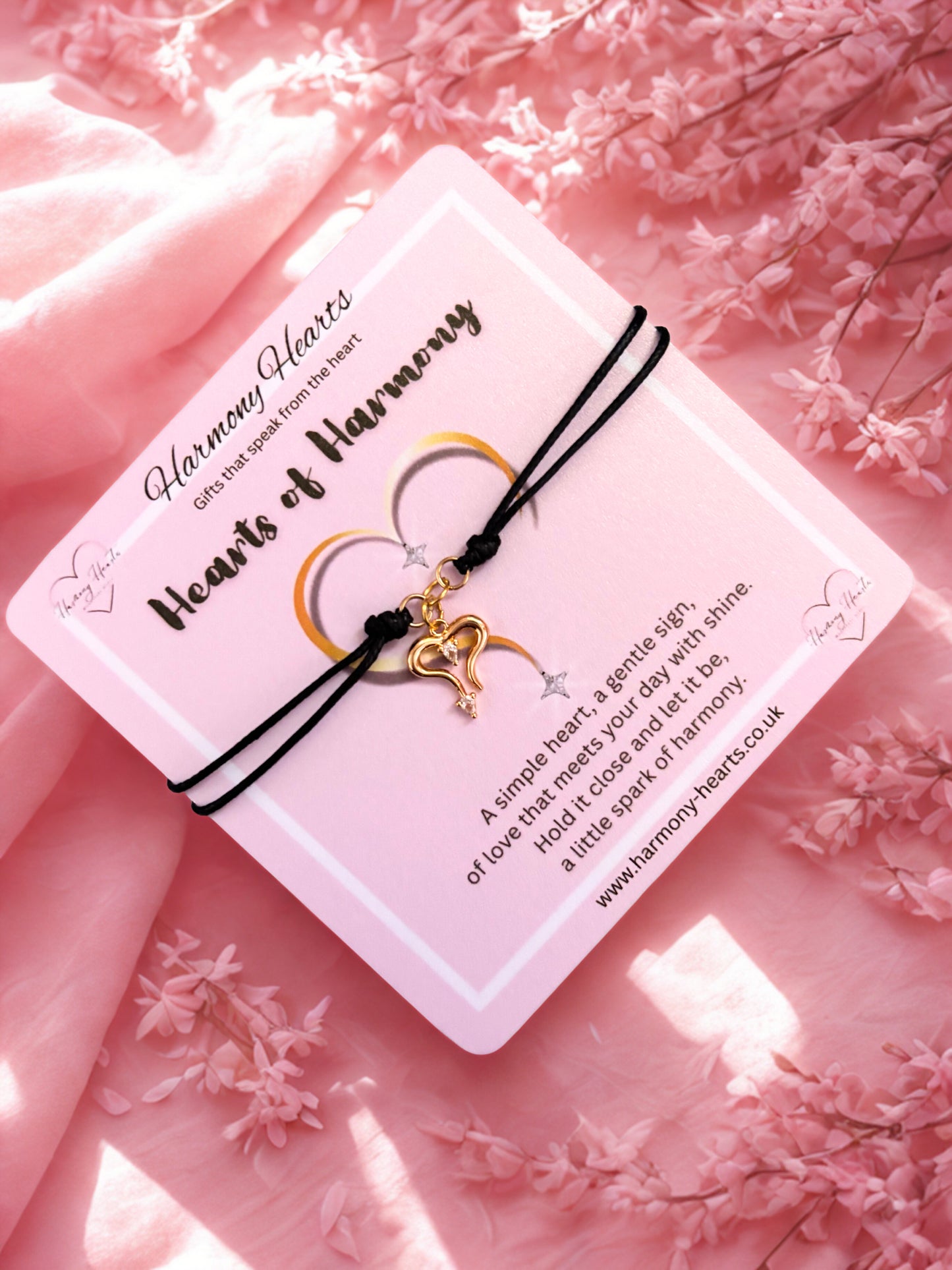 Bracelet with heart charm on a pink floral background