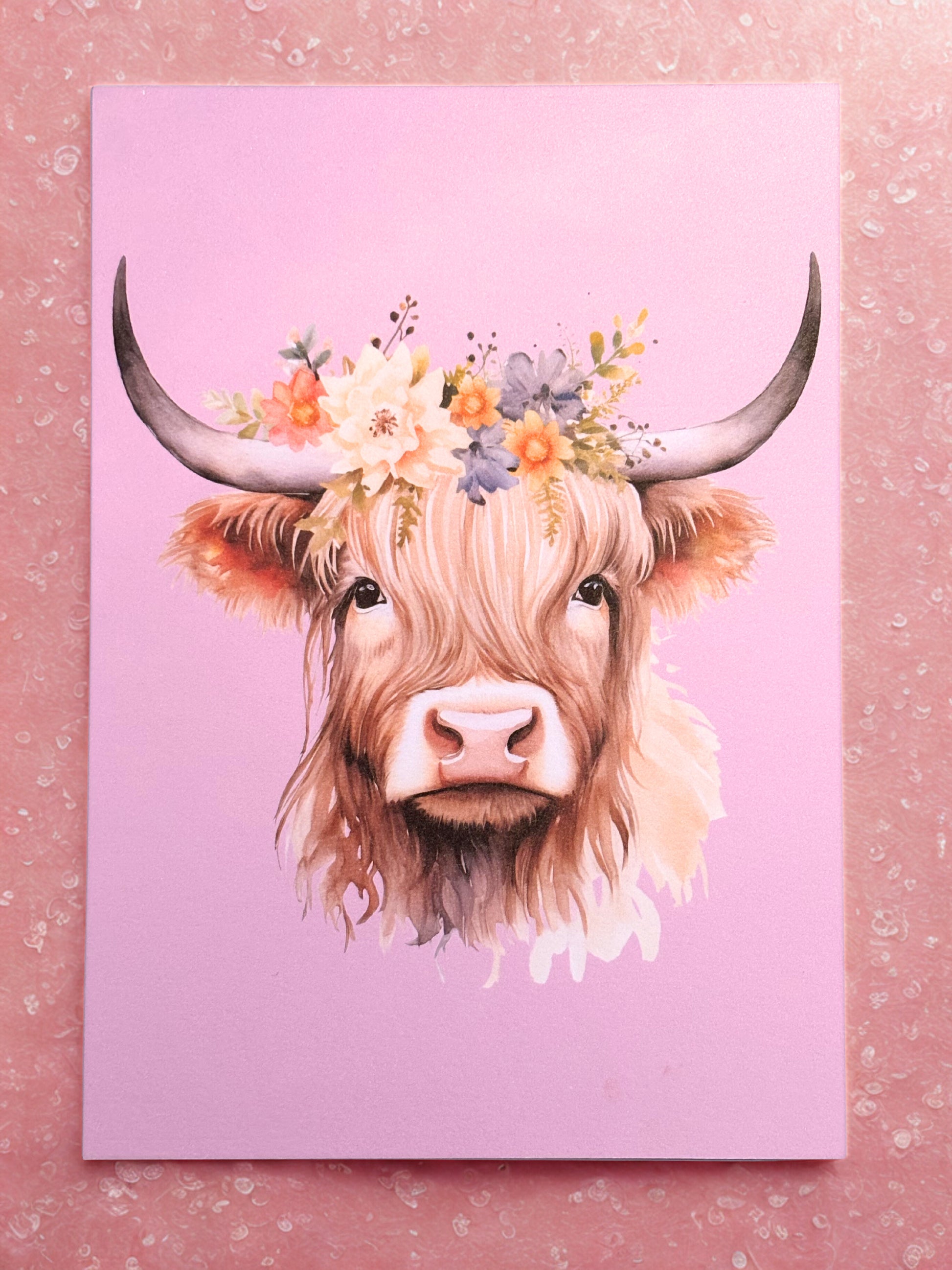 Print of a highland cow with floral headband on a pink background